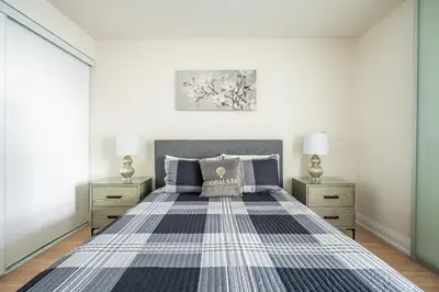 a bedroom with a bed and two night stands at Cozy 1 BR & Den Condo in North York Free Parking in Toronto