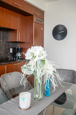 a vase filled with white flowers on a table at Cozy 1 BR & Den Condo in North York Free Parking in Toronto