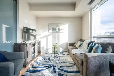 a living room with a couch and a table at Cozy 1 BR & Den Condo in North York Free Parking in Toronto