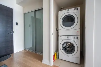 a laundry room with a washer and dryer at Cozy 1 BR & Den Condo in North York Free Parking in Toronto