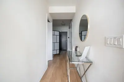 a glass table in a hallway with a mirror at Cozy 1 BR & Den Condo in North York Free Parking in Toronto