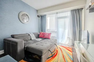 a living room with a couch and a window at Modern 2Bd 2Ba Skyscraper Free parking in Toronto