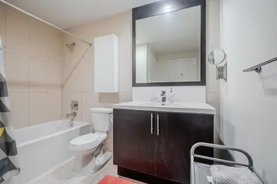 a bathroom with a sink and a toilet and a mirror at Modern 2Bd 2Ba Skyscraper Free parking in Toronto