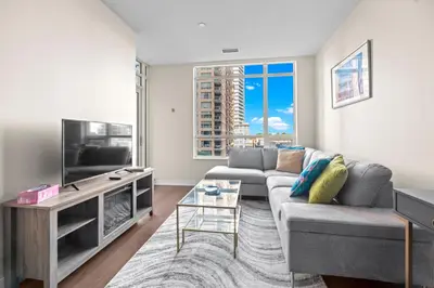 a living room with a couch and a tv at luminous 2-Bedroom Apartment with Balcony in Toronto