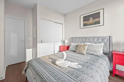 a bedroom with a bed with a white animal on it at luminous 2-Bedroom Apartment with Balcony in Toronto