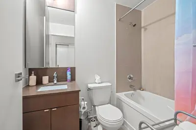 a bathroom with a toilet and a sink and a tub at luminous 2-Bedroom Apartment with Balcony in Toronto