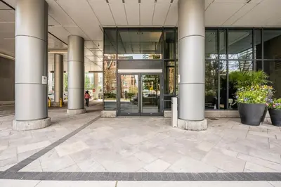 an entrance to a building with columns and plants at luminous 2-Bedroom Apartment with Balcony in Toronto