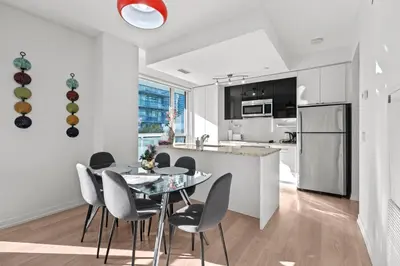 a kitchen and dining room with a table and chairs at Modern New 2Bd 2Ba &Den Condo with Balcony in Toronto