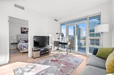 a living room with a couch and a tv at Modern New 2Bd 2Ba &Den Condo with Balcony in Toronto