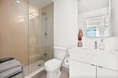 a bathroom with a toilet and a sink and a shower at Modern New 2Bd 2Ba &Den Condo with Balcony in Toronto