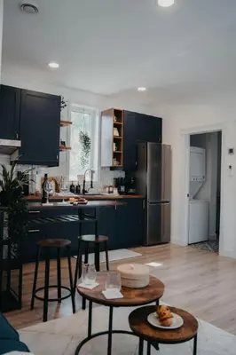 a kitchen with black cabinets and a table and chairs at The Hideout in Barrie