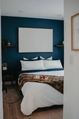 a bedroom with a large bed with a blue wall at The Hideout in Barrie
