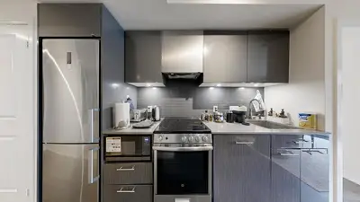 a kitchen with a stove and a refrigerator at Cozy 1BR Condo in Core Toronto in Toronto