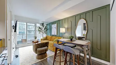 a living room with green walls and a table and chairs at Cozy 1BR Condo in Core Toronto in Toronto