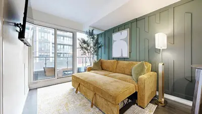 a living room with a couch and a large window at Cozy 1BR Condo in Core Toronto in Toronto