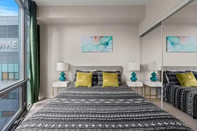 a bedroom with a large bed with yellow pillows at 1BR High Floor View Downtown Toronto in Toronto
