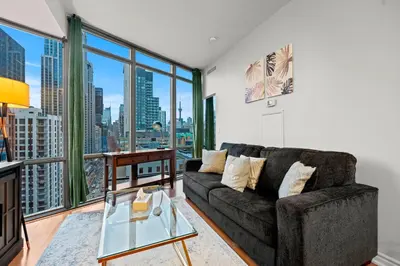 a living room with a couch and a large window at 1BR High Floor View Downtown Toronto in Toronto