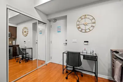 a room with two chairs and a clock on the wall at 1BR High Floor View Downtown Toronto in Toronto