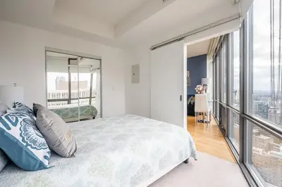 a bedroom with a bed and a large window at 1BR High Floor View Downtown Toronto in Toronto