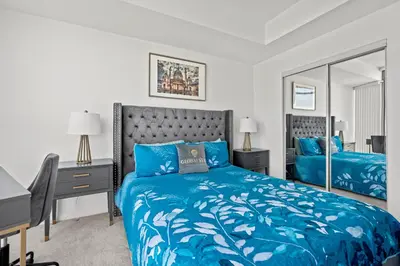 a bedroom with a blue bed and a desk and mirror at Magnificent 1 Bd High floor view Downtown Toronto in Toronto