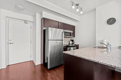 a kitchen with a stainless steel refrigerator and a counter at Magnificent 1 Bd High floor view Downtown Toronto in Toronto