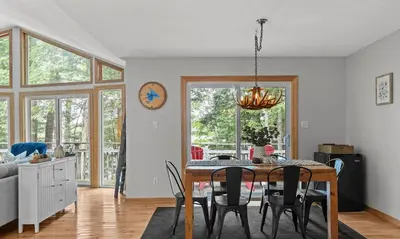 a dining room and living room with a table and chairs at Sunset Heaven 3 Bedroom Lakefront Retreat in Bracebridge