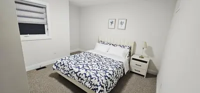 a white bedroom with a bed and a window at Muskoka Luxury Getaway in Gravenhurst