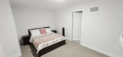 a bedroom with a bed in a white room at Muskoka Luxury Getaway in Gravenhurst