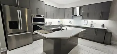 a kitchen with a sink and a stainless steel refrigerator at Muskoka Luxury Getaway in Gravenhurst