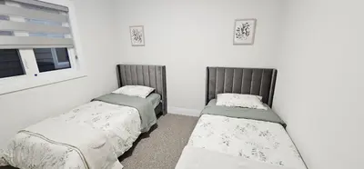 two twin beds in a room with a window at Muskoka Luxury Getaway in Gravenhurst