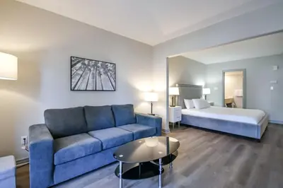 a living room with a couch and a bed at 2BR King Suite Pool Sauna Heated Pool in Shanty Bay
