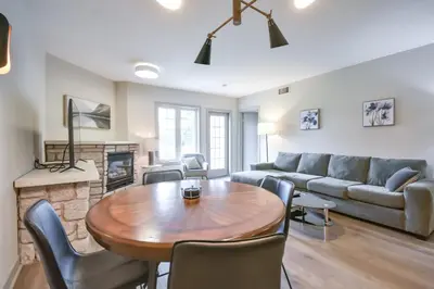 a living room with a table and a couch at 2BR King Suite Pool Sauna Heated Pool in Shanty Bay
