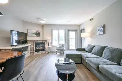 a living room with a couch and a table at 2BR King Suite Pool Sauna Heated Pool in Shanty Bay