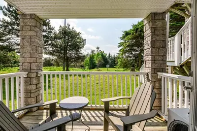 a screened porch with two chairs and a table at 2BR King Suite Pool Sauna Heated Pool in Shanty Bay