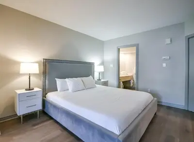 a bedroom with a large white bed and a desk at 2BR King Suite Pool Sauna Heated Pool in Shanty Bay