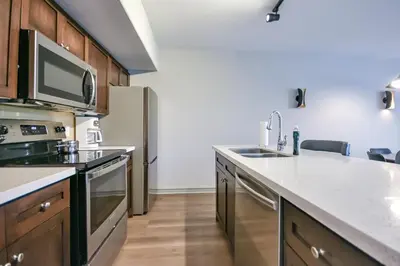 a kitchen with a sink and a refrigerator at Perfect Jacuzzi Suite at Highland in Shanty Bay