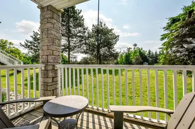 a deck with two chairs and a table at Perfect Jacuzzi Suite at Highland in Shanty Bay