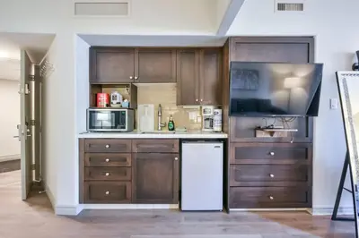 a kitchen with wooden cabinets and a white refrigerator at The King Studio Sauna Haven in Shanty Bay