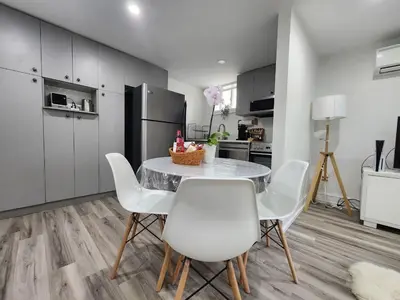 a kitchen with a table and chairs and a refrigerator at Entire 2BR Apt in Midtown Toronto, walk to Subway & Shops in Toronto
