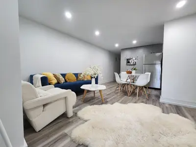 a living room with a blue couch and a table at Entire 2BR Apt in Midtown Toronto, walk to Subway & Shops in Toronto