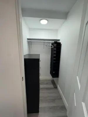 a hallway with a walk in closet with a black cabinet at Studio Basement Apartment in Kitchener
