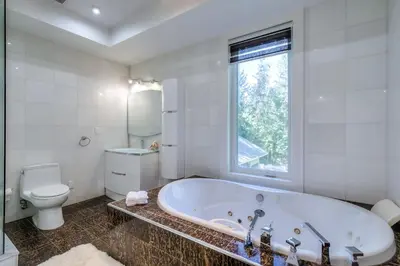 a white bathroom with a tub and a toilet at Private Oasis in King City in King City