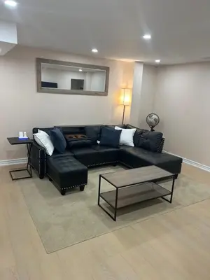 a living room with a black couch and a table at North Brampton Getaway in Brampton