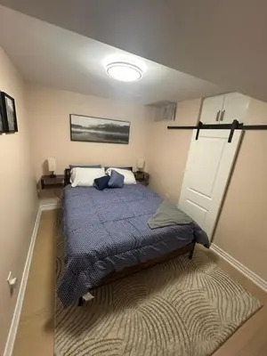 a bedroom with a bed with a blue comforter at North Brampton Getaway in Brampton