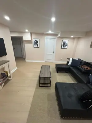 a living room with a black couch and a table at North Brampton Getaway in Brampton