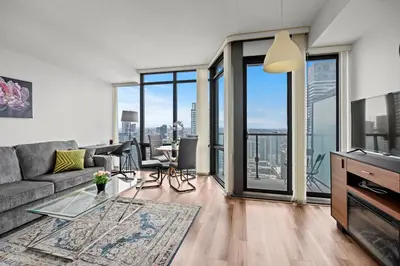 a living room with a couch and a glass table at Attractive 1 Bedroom High Floor with Skyline View in Toronto