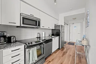 a kitchen with a stove and a microwave at Attractive 1 Bedroom High Floor with Skyline View in Toronto