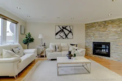 a living room with two white couches and a fireplace at Prestige Manor, 6BR with Sunroom and 3400 Sqft by Instant Suites in Mississauga