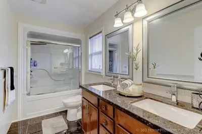 a bathroom with two sinks and a shower and a toilet at Prestige Manor, 6BR with Sunroom and 3400 Sqft by Instant Suites in Mississauga