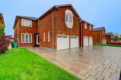 a brick house with two garages and a driveway at Prestige Manor, 6BR with Sunroom and 3400 Sqft by Instant Suites in Mississauga